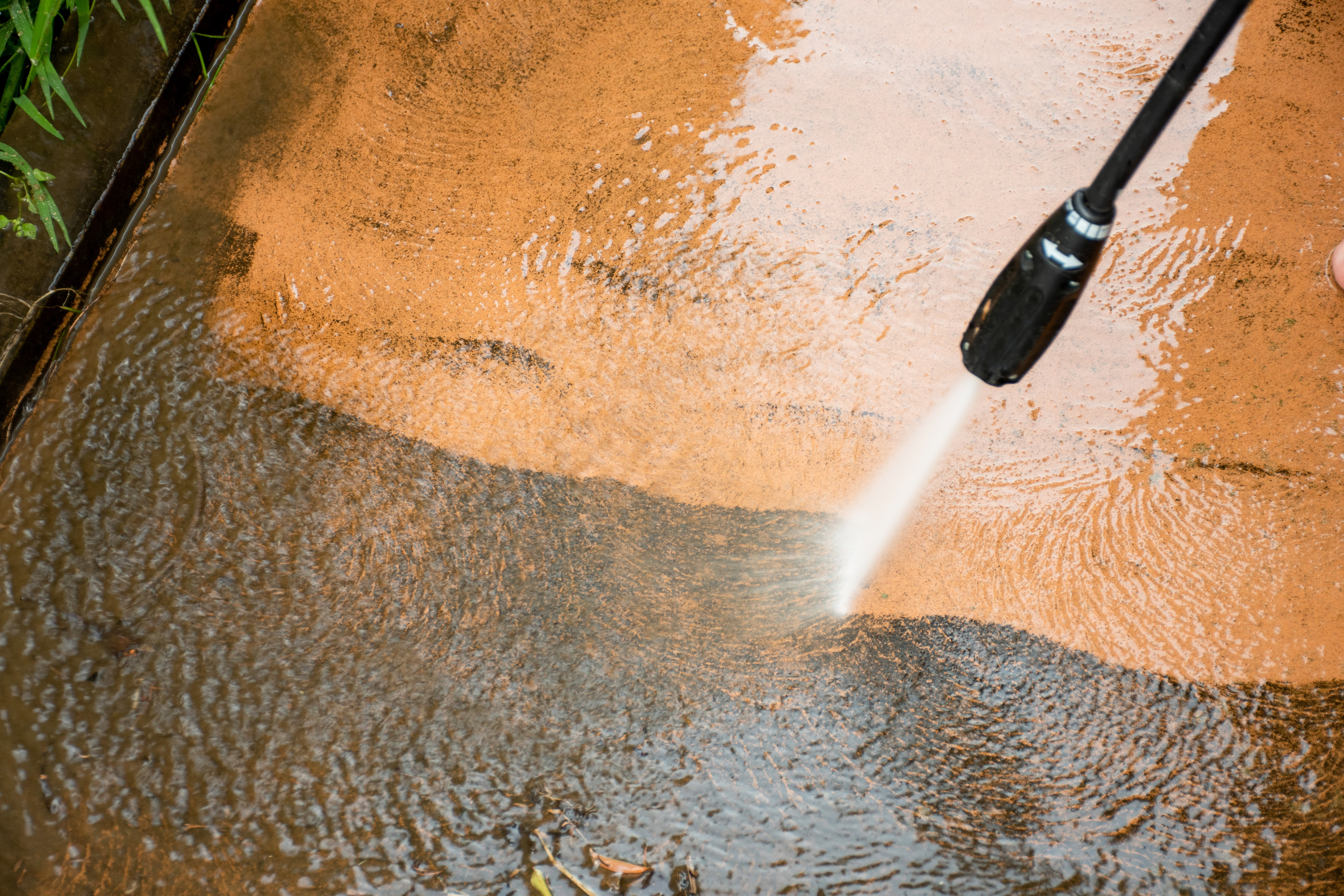 close up picture of a pressure washing head spraying water on a surface