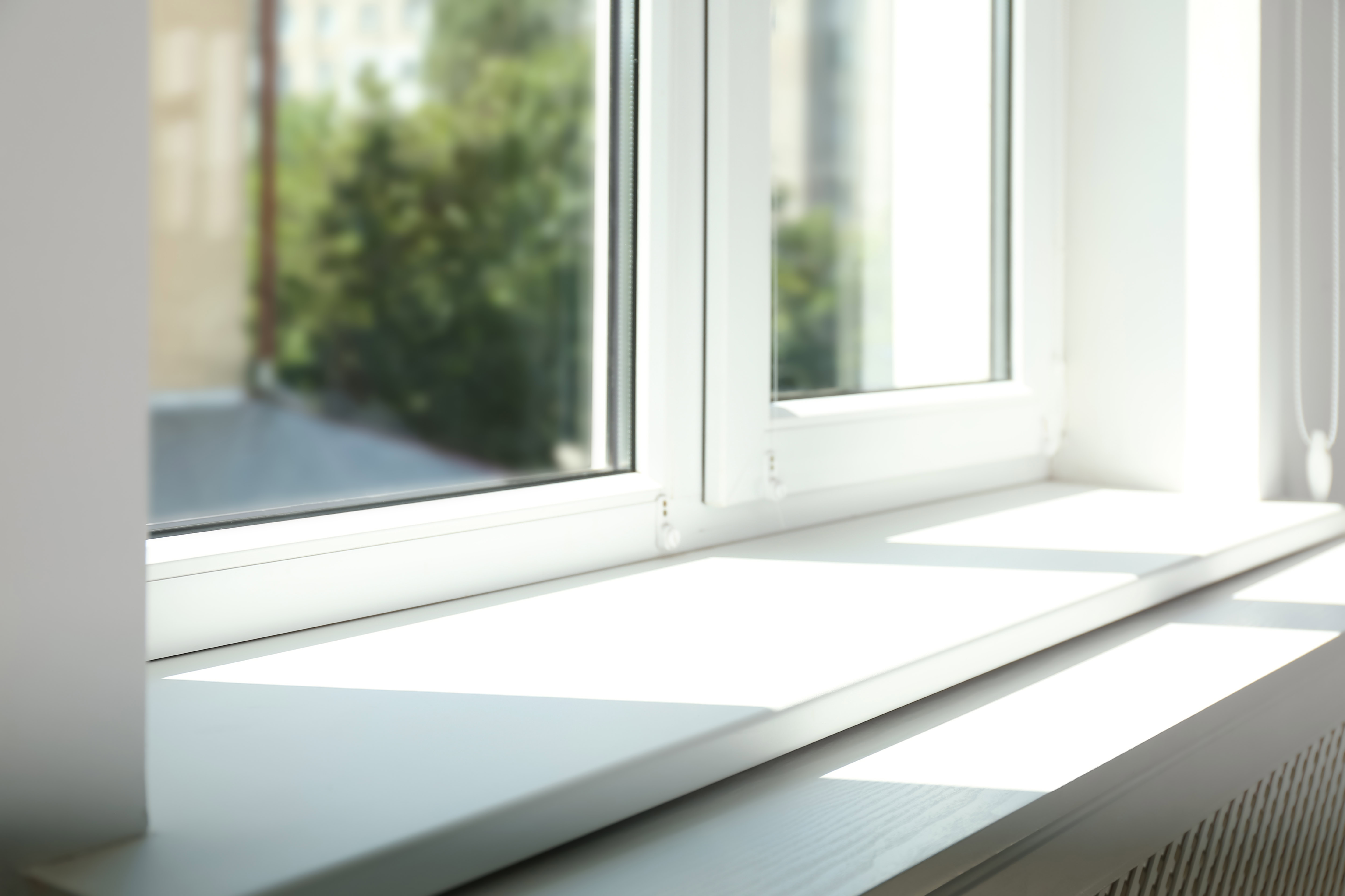 close up picture of the bottom of a window in a home with a white sill